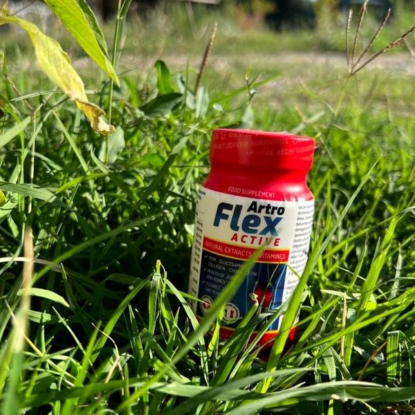 Flacone di Artroflex Active con tappo rosso appoggiato sull'erba