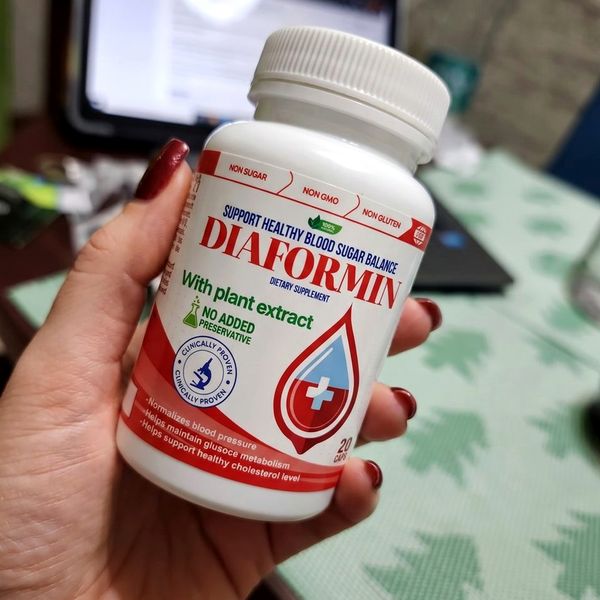 Barattolo bianco e rosso di Diaformin da 20 capsule tenuto in mano
