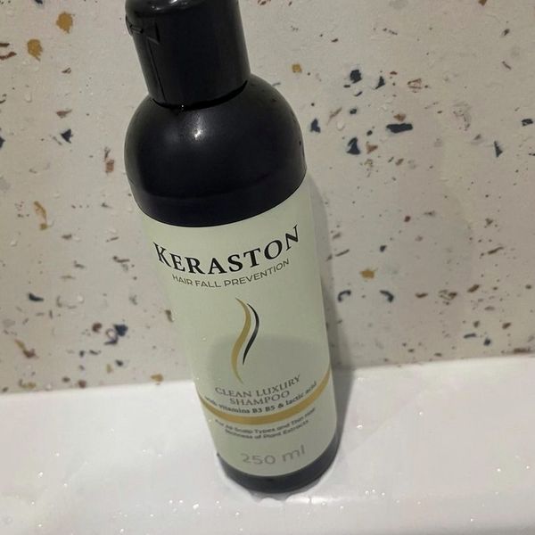 Flacone di shampoo Keraston da 250 ml appoggiato su un piano